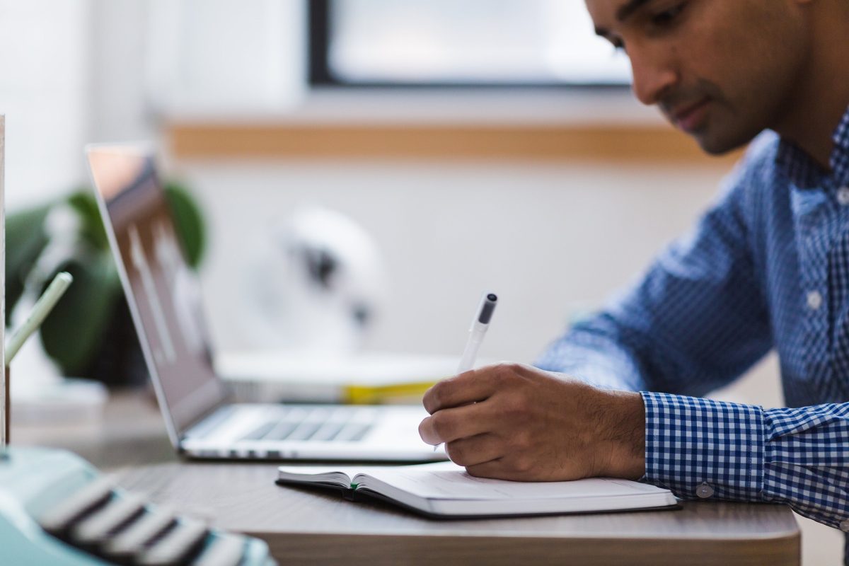 homme écrivant à son bureau